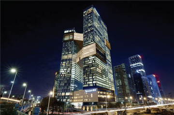 A tall building lit up at nightDescription automatically generated